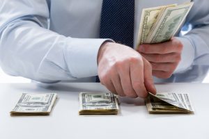 Bank teller counting dollar banknotes